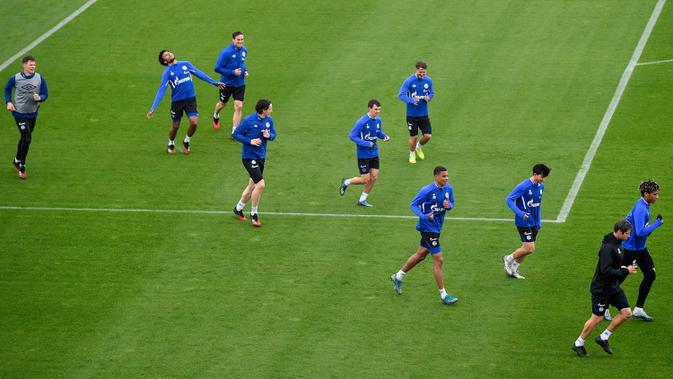PEMAIN SCHALKE BERLATIH: Pemain FC Schalke 04 melakukan pemanasan selama sesi latihan di Gelsenkirchen, Jerman, Rabu, (29/4/2020). Meski ada larangan pertemuan besar hingga Agustus karena pandemi Covid-19, para pejabat sepakbola berharap untuk memulai kembali liga di bulan Mei. (AP/Martin Meissner)