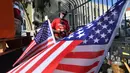 Bendera Amerika Serikat (AS) dikibarkan di tempat tinggal veteran yang bernama Kendrick Bailey di Los Angeles, California (10/11). Kendrick Bailey merupakan veteran AS yang pernah bertugas di Vietnam. (AFP Photo/Frederic J. Brown)