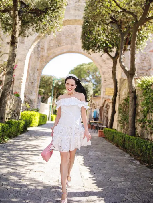 Dress sabrina berwarna putih jadi pilihan sempurna untuk liburan musim panas. [Instagram/shandyaulia]