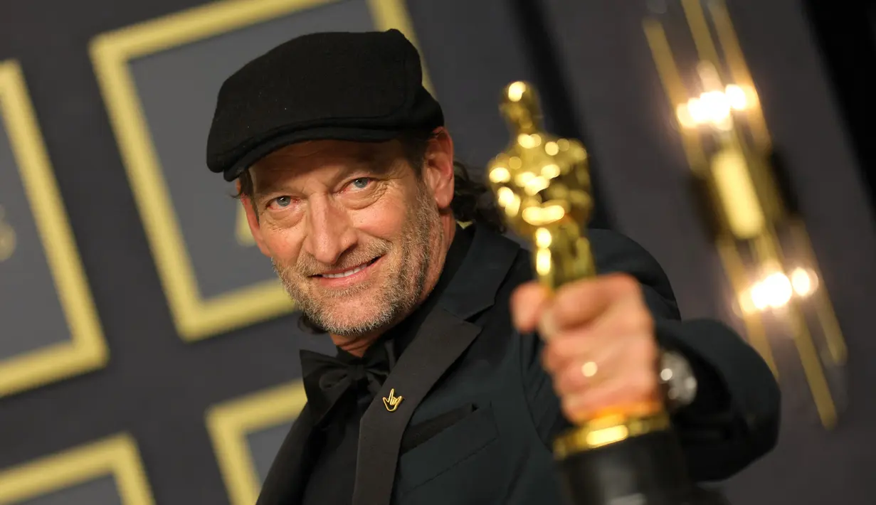 Aktor AS Troy Kotsur berpose dengan Piala Oscar di ruang pers Academy Award ke-94 di Dolby Theatre, Hollywood, Minggu (27/3/2022). Troy Kotsur memenangkan piala Oscar dalam kategori pendukung terbaik untuk perannya sebagai seorang nelayan dan ayah dalam film CODA. (Mike Coppola/Getty Images/AFP)