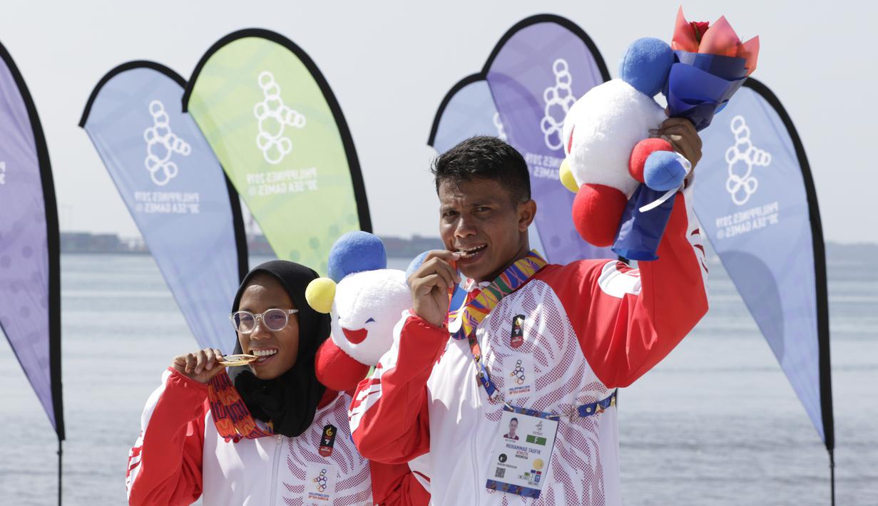 Atlet modern pentathlon, Muhammad Taufik dan Dea Salsabila, berpose usai meraih medali pada nomor beach triathle individual SEA Games 2019 di Subic, Jumat (6/12). Taufik meraih perunggu dan Dea meraih emas. (Bola.com/M Iqbal Ichsan)
