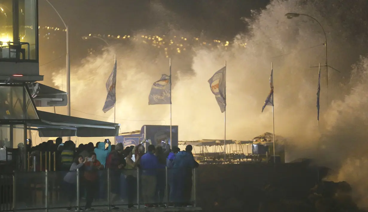 Sejumlah turis asik menonton ombak yang tinggi di pantai kota Vina del Mar, Chile,  (25/1).  Ombak besar ini berasal dari air laut Samudera Pasifik. (REUTERS / Rodrigo Garrido)