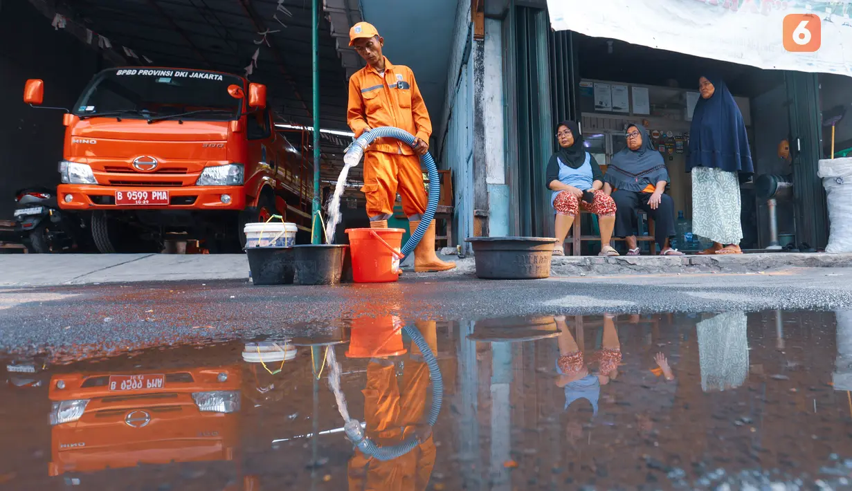 Petugas mengisi wadah milik warga saat pendistribusian air bersih oleh BPBD DKI Jakarta di Cilandak Timur, Jakarta Selatan, Senin (21/9/2026). Penyaluran dilakukan untuk membantu warga memenuhi kebutuhan air selama kekeringan berlangsung. (KLY/Budy Santoso)