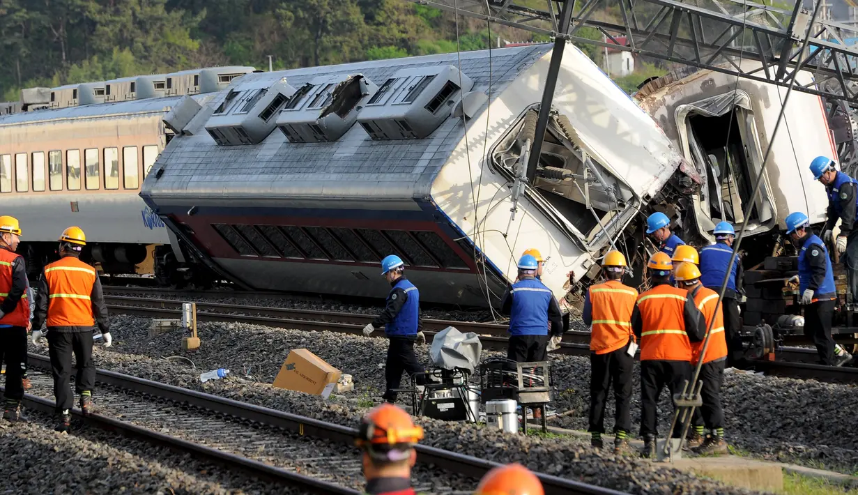 Petugas dikerahkan ke lokasi tergelincirnya kereta penumpang dan keluar dari jalurnya di kota pelabuhan selatan Yeosu, Korea Selatan, Jumat (22/4). Kecelakaan itu menyebabkan masinis tewas dan delapan penumpang luka-luka. (Hwang Hee-kyu/News1 via REUTERS)