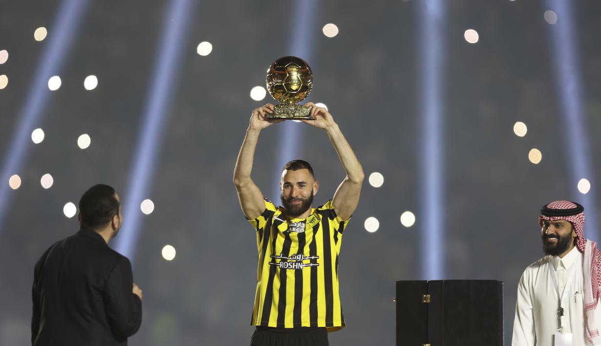 Karim Benzema memamerkan trofi Ballon d'Or kepada para suporter Al Ittihad dalam acara perkenalannya di Jeddah. (AP Photo)
