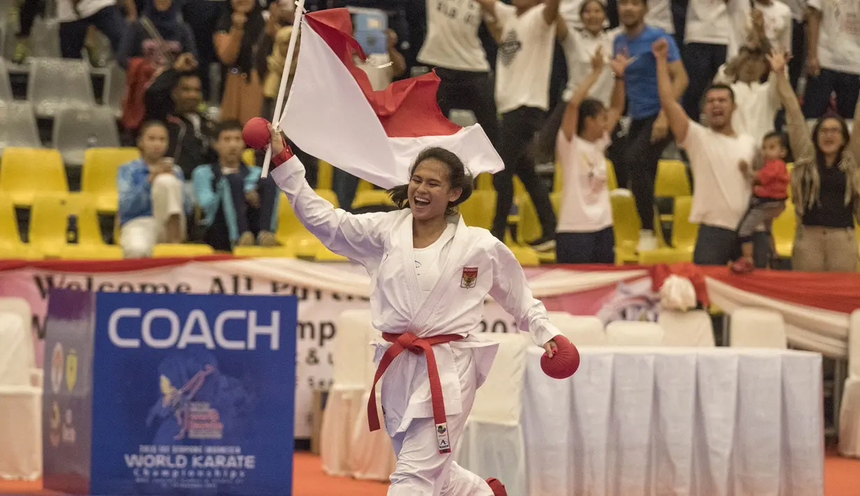 Karateka Indonesia, Ceyco Georgia Zefanya mengibarkan merah putih usai meraih emas pada Kejuaraan Dunia Karate Junior, Cadet dan U-21 di ICE BSD, Tangerang, Jumat (13/11/2015). (Bola.com/Vitalis Yogi Trisna) 