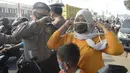 Anggota polisi dari Polsek Parung membantu memasangkan masker kepada pengendara sepeda motor di depan Polsek Parung, Kabupaten Bogor, Jawa Barat, Rabu (2/9/2020). Pembagian masker gratis ini untuk mengajak masyarakat hidup sehat dan mencegah penular COVID-19. (merdeka.com/Dwi Narwoko)