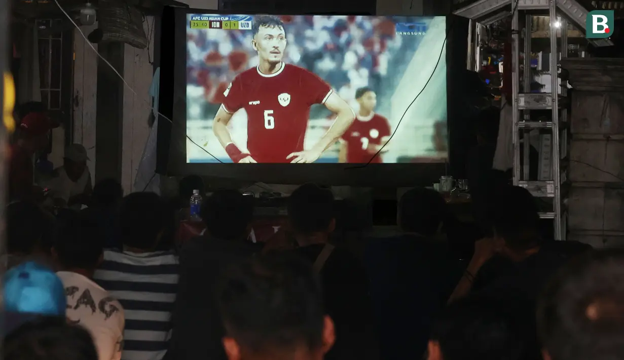 Warga asik menonton pertandingan Timnas Indonesia U-23 vs Uzbekistan di Piala Asia U-23 saat nobar di kampung Sampora, Cisauk, Tangerang, Selasa (29/4/2024). (Bola.com/M Iqbal Ichsan)