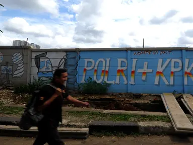 Seorang laki-laki melintas di depan mural di sisi Jalan Juanda, Depok, Jawa Barat. Foto diambil pada Senin (2/3/2015). (Liputan6.com/Helmi Fithriansyah)