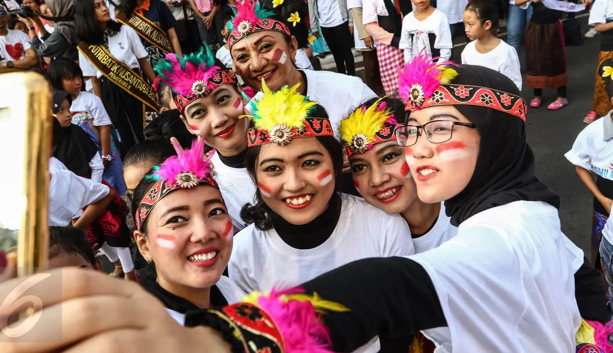 Sejumlah peserta berfoto sebelum mengikuti flashmob 1745 penari di kawasan Senayan, Jakarta, Minggu (21/8). Kegiatan bertajuk "Aku Indonesia-Bagimu Negeri Kami Menari" itu merupakan bagian dari perayaan HUT RI ke 71. (Liputan6.com/Fery Pradolo)