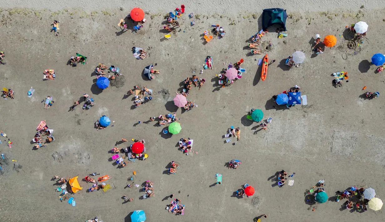 Foto udara orang-orang yang berada di bawah sinar matahari di sebuah pantai di Puerto Madryn, provinsi Chubut, Argentina pada tanggal 26 Januari 2024. (MAXI JONAS/AFP)