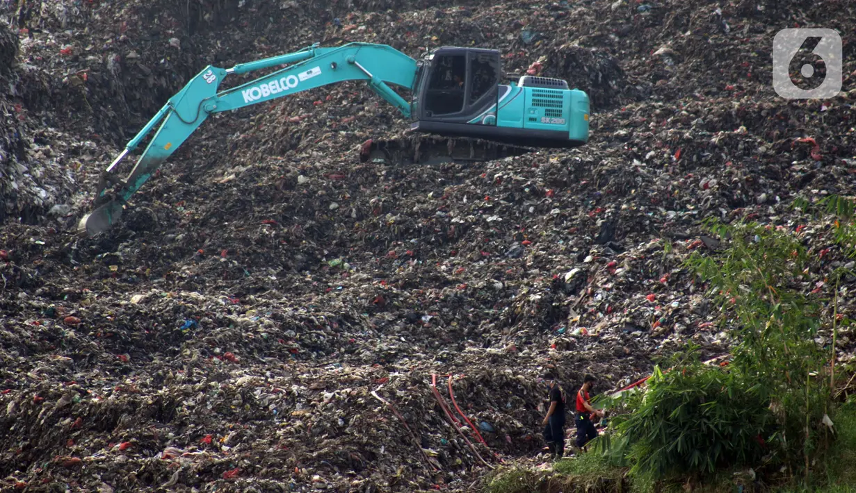 Alat berat memindahkan tumpukan sampah dari Tempat Pembuangan Akhir (TPA) Cipeucang yang masuk ke area Sungai Cisadane, Serpong, Tangerang Selatan, Rabu (3/6/2020). Sebelumnya, pada Jumat (22/5/) lalu turap yang menopang tumpukan sampah di TPA tersebut jebol. (Liputan6.com/Helmi Fithriansyah)