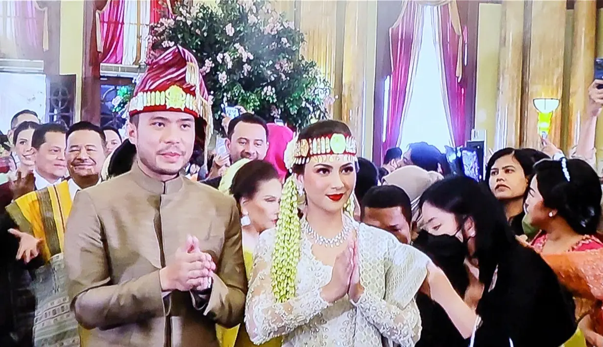 Ruangan di dekorasi dengan nuansa adat Batak kental. Kedua pengantin pun bak raja dan ratu dalam sebuah kerajaan. Jessica Mila dan Yakup Hasibuan mengenakan hiasan kepala bernama sortali. Berikut suasana kemeriahan resepsi pernikahan Yakup dan Jessica. [KapanLagi.com/Muhammad Akrom Sukarya]