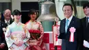 Menteri Keuangan Jepang Taro Aso (kanan) saat akan membunyikan lonceng saat upacara pembukaan Bursa Efek Tokyo di Tokyo, Jepang, Jumat (4/1). Bursa Efek Tokyo menggelar seremoni dalam pembukaan perdagangan saham 2019. (AP Photo/Eugene Hoshiko)