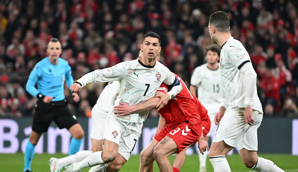 Pemain Portugal, Cristiano Ronaldo, dijaga ketat bek Denmark dalam laga leg pertama perempat final UEFA Nations League 2024/2025 yang digelar di Stadion Parken, Copenhagen, Jumat (21/3/2025) dini hari WIB. (AFP/Jonathan Nackstrand)