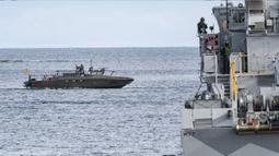 Sebuah 'kapal musuh' dalam bentuk kapal Swedia "Stridsbat 90" (kiri) terlihat di depan kapal penyapu ranjau HMS Ulvon saat latihan ranjau di luar Vastervik, Swedia, 21 September 2021. Latihan ini melibatkan sekitar 2.000 orang dan sekitar 30 kapal dari 13 negara. (JOHAN NILSSON/TT NEWS AGENCY/AFP)
