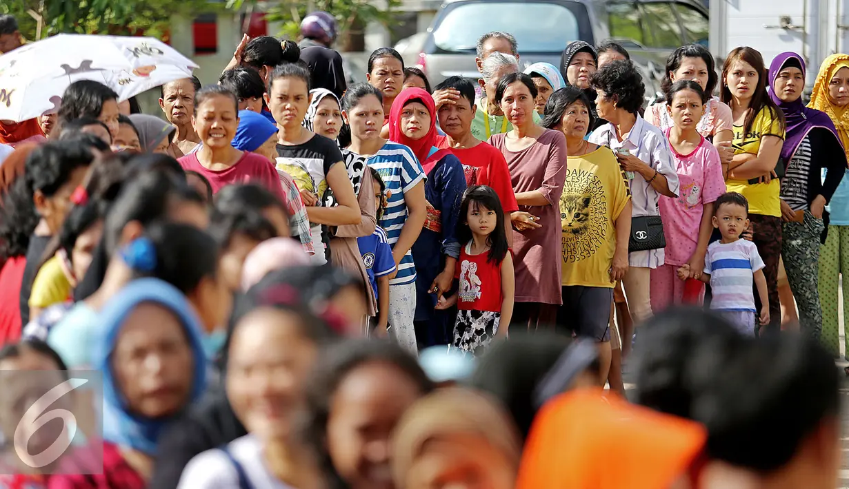 Warga mengantre untuk mendapatkan minyak goreng murah yang didistribusikan oleh Sinar Mas pada acara Bazar Rakyat di Rusun Marunda, Jakarta Utara, Kamis (30/6). (Liputan6.com/Angga Yuniar)