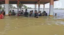 Anak-anak berkumpul saat banjir di Desa Sukalaksana Kabupaten Bekasi, Jawa Barat, Senin (22/02/2021). Hujan dengan intensitas tinggi turun sejak Jumat, 19 Februari 2021 mengakibatkan air di aliran sungai meluap. (Liputan6.com/Herman Zakharia)