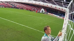 Kiper Bayern Munchen, Manuel Neuer memotong jaring gawang saat merayakan timnya meraih trofi Liga Champions usai mengalahkan PSG pada pertandingan final di stadion Luz di Lisbon (23/8/2020). Munchen menang tipis atas PSG 1-0. (AFP/Lluis Gene)