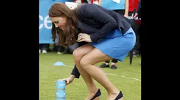 Duchess of Cambridge, Kate Middleton, saat bersiap memainkan permainan asli Afrika Selatan "Tiga Kaleng" di Commonwealth Games Village di Glasgow, Skotlandia, (29/7/2014). (REUTERS/Danny Lawson)