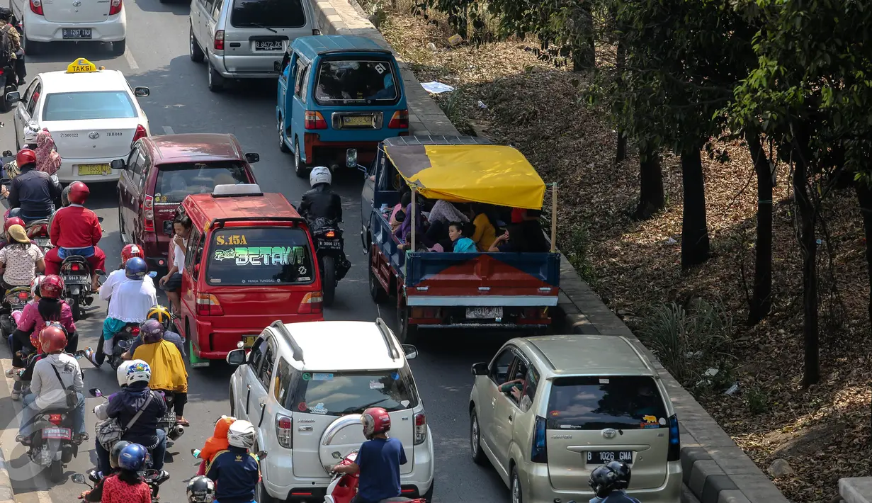 Kendaraan bak terbuka berisi warga terjebak kemacetan di Jakarta, Minggu (19/7/2015). Meskipun membahayakan, mobil pick up menjadi pilihan warga untuk bersilaturahmi saat momen Lebaran. (Liputan6.com/Faizal Fanani)