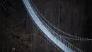 Foto yang diambil pada 3 Maret 2023 menunjukkan jembatan gantung yang sedang dibangun, menghadap ke air terjun di Todtnau, barat daya Jerman. Pembangunan jembatan sepanjang 450 meter yang digantung dengan ketinggian hingga 120 meter ini diharapkan selesai pada Mei 2023 dan menjadi daya tarik wisata utama di Black Forest. (PATRICK HERTZOG / AFP)