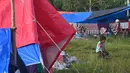 Seorang gadis duduk di antara tenda-tenda saat orang-orang yang terkena dampak tinggal di kamp sementara di Mamuju, Senin (18/1/2021). Gempa berkekuatan magnitudo 6,2 yang terjadi pada Jumat (15/1) dini hari mengakibatkan puluhan orang meninggal dunia. (AFP/Adek Berry)