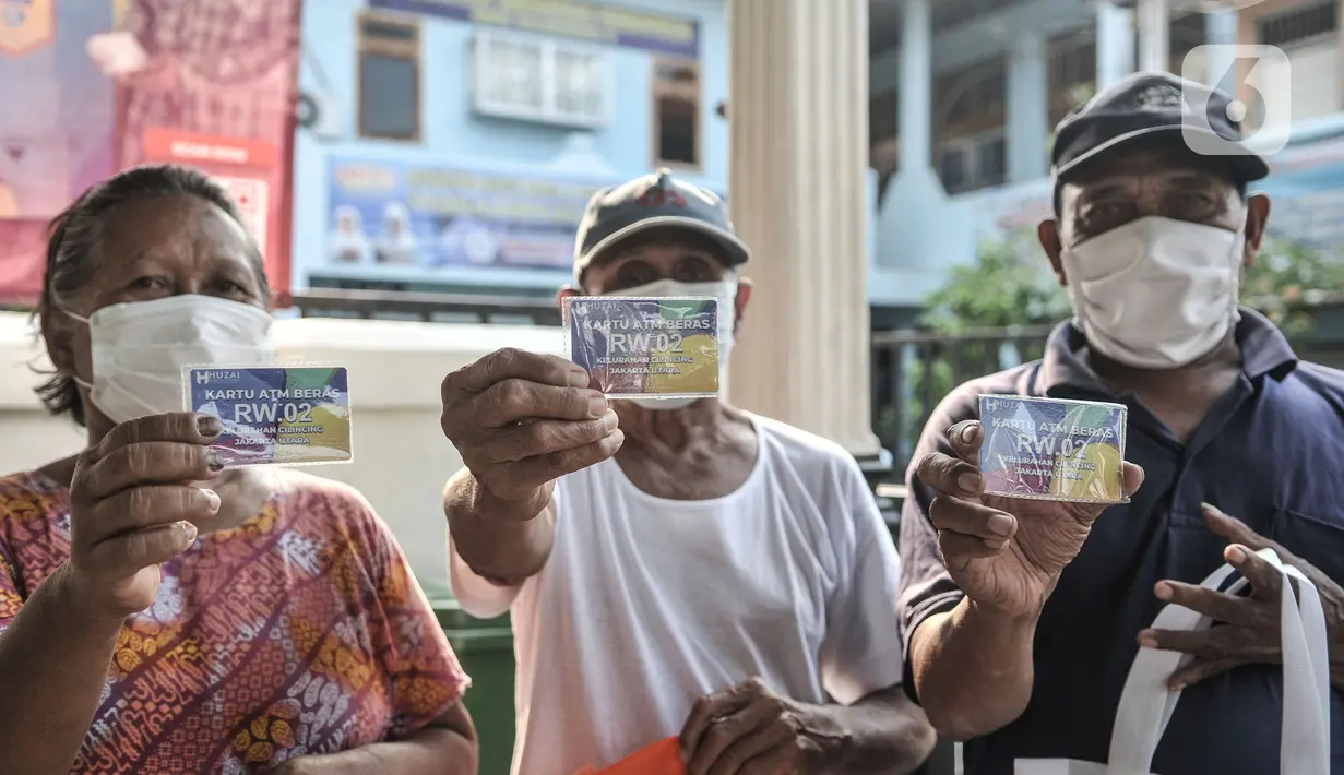 Warga lansia menunjukkan kartu ATM Beras saat menerima bantuan di Kantor RW 02, Kelurahan Cilincing, Jakarta Utara, Rabu (17/3/2021).  Pembuatan ATM Beras secara mandiri sebagai program ketahanan pangan di masa pandemi Covid-19. (merdeka.com/Iqbal S. Nugroho)