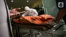 Petugas membawa kantong jenazah korban kebakaran Lapas Kelas I Tangerang usai diturunkan dari ambulans di RS Polri Kramat Jati, Jakarta, Rabu (8/9/2021). Sebanyak 41 warga binaan tewas akibat kebakaran yang terjadi di Blok C 2 Lapas Kelas I Tangerang. (Liputan6.com/Faizal Fanani)