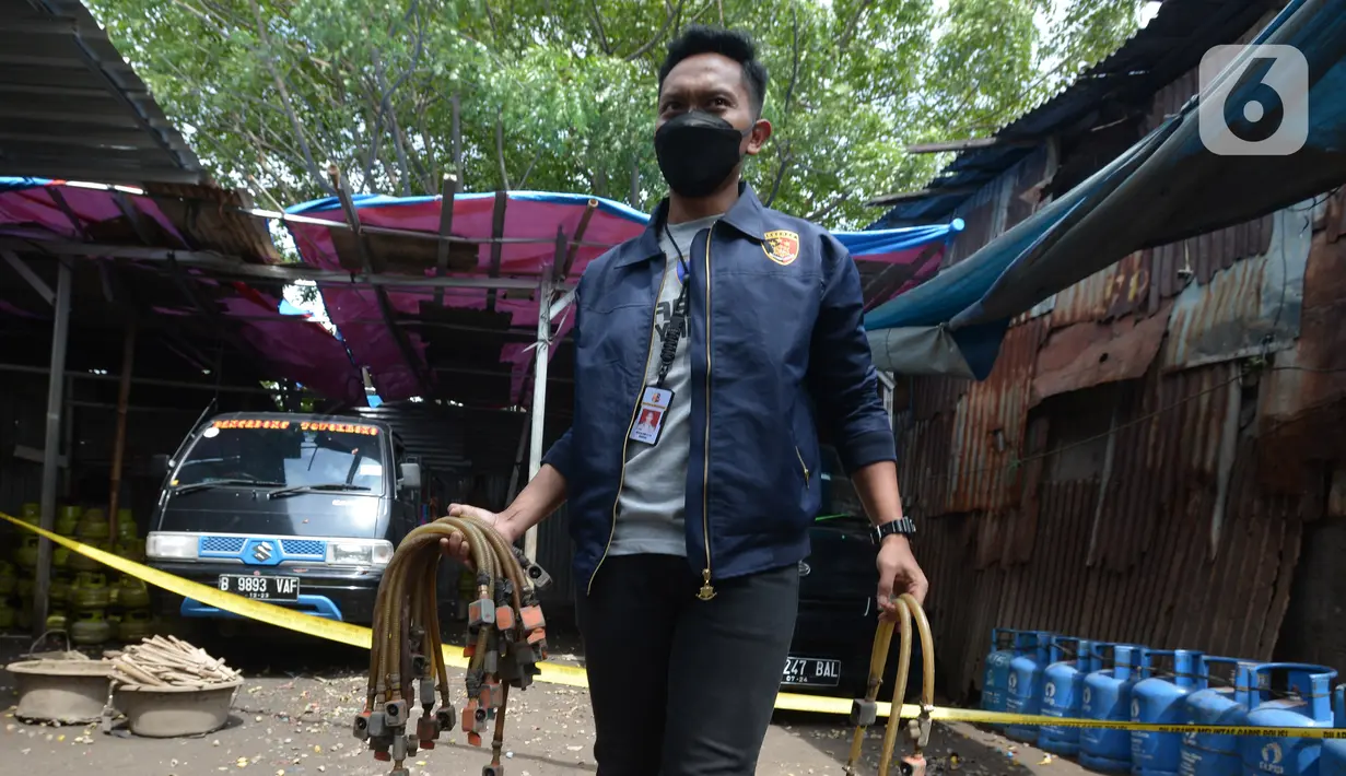 Polisi saat mengamankan barang bukti selang gas subsidi di Meruya Utara, Jakarta Barat, Selasa (6/4/2021). Mabes Polisi mengamankan tempat pengoplosan gas subsidi LPG 3 kg menjadi gas 12 kg.  (merdeka.com/Imam Buhori)