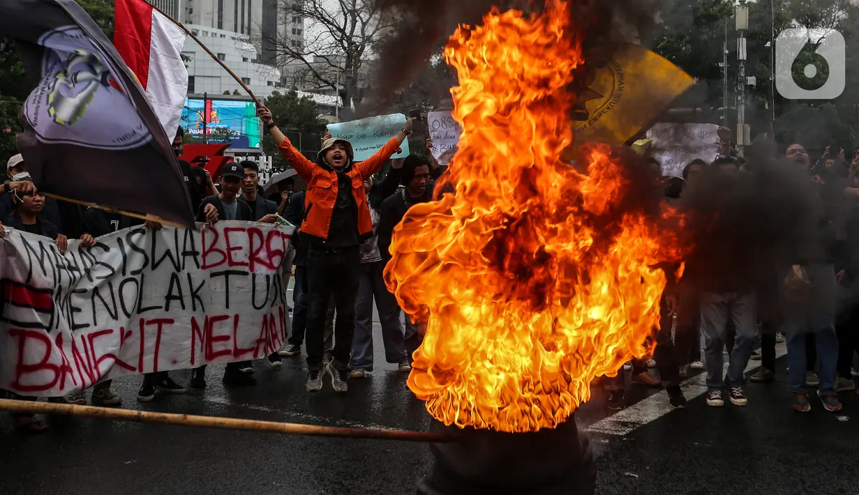 Mahasiswa membakar ban bekas saat demo menolak kenaikan harga Bahan Bakar Minyak (BBM) di kawasan Patung Kuda, Jakarta Pusat (Jakpus), Kamis (8/9/2022). Massa membentuk lingkaran dan menyaksikan ban terbakar. Asap hitam mengepul begitu ban dibakar. (Liputan6.com/Johan Tallo)