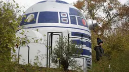 Seorang anak berada di dekat ventilasi bunker nuklir yang menyerupai robot R2-D2 film Star Wars di sebuah taman di Praha, Republik Ceko, (28/10). Kreatifitas seniman tersebut menghebohkan warga Praha. (AP Photo/Petr David Josek)