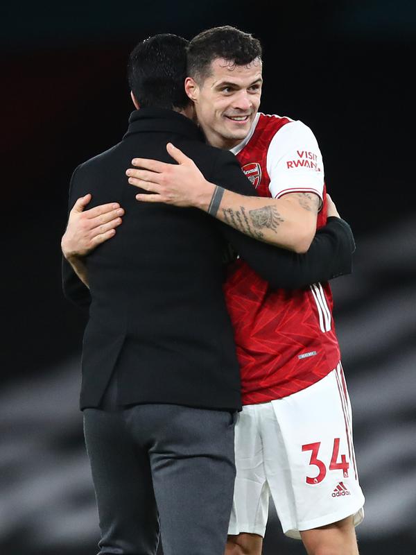Pelatih Arsenal, Mikel Arteta memeluk gelandang Granit Xhaka usai pertandingan melawan Chelsea pada lanjutan Liga Inggris di Stadion Emirates di London, Minggu (27/12/2020). Dengan tambahan tiga poin, Arsenal berada di posisi ke 15 klasemen. (AFP/Pool/Adrian Dennis)
