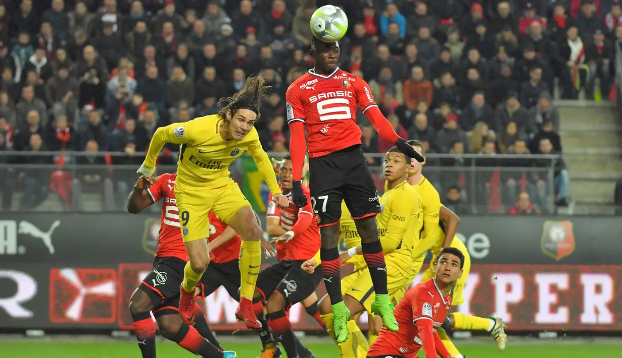 Pemain Rennes, Hamari Traore (kanan) menghalau bola dari pemain PSG, Edinson Cavani pada laga Ligue 1 Prancis di Roazhon Park, Rennes, (16/12/2017). PSG menang 4-1. (AFP/Loic Venance)