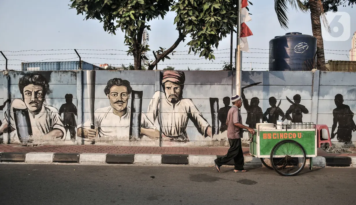 Pedagang melintasi mural bertemakan perjuangan Kemerdekaan Republik Indonesia di Jalan Pluit Raya III, Jakarta, Senin (10/8/2020). Mural itu diharapkan menjadi media agar masyarakat selalu mengingat sejarah dan menghargai jasa para pahlawan dalam memerdekakan Tanah Air. (merdeka.com/Iqbal Nugroho)