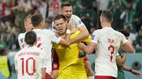 Kiper Polandia,Wojciech Szczesny, melakukan selebrasi usai mengagalkan tendangan penalti pemain Arab Saudi pada laga Piala Dunia di Stadion Education City, Qatar, Sabtu (26/11/2022). (AP/Aijaz Rahi)