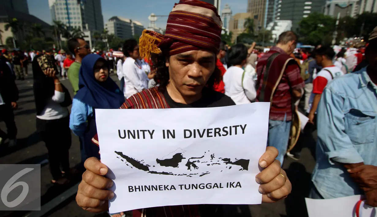 Seorang peserta membawa poster saat mengikuti aksi Parade Bhineka Tunggal Ika, Jakarta, Sabtu (19/11). Parade ini terselenggara sebagai bentuk menyikapi keprihatinan atas situasi belakangan yang berpotensi memecah belah. (Liputan6.com/Gempur M. Surya)
