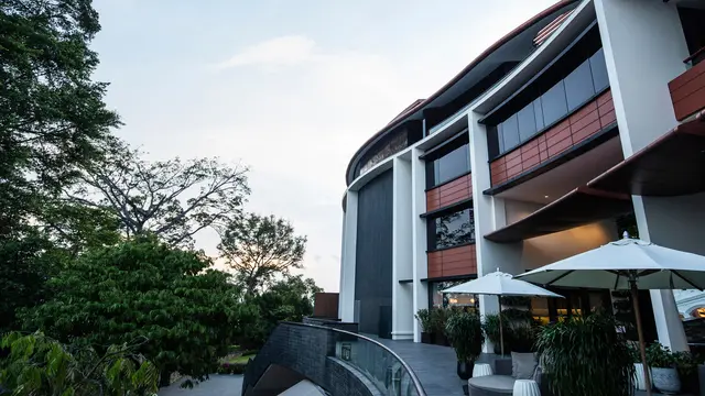 Meja-meja dengan payung terlihat di luar Hotel Capella, Pulau Sentosa, Singapura, Selasa (5/6). Minimnya tingkat pemesanan di Hotel Capella menjadi satu tanda bahwa tempat itu sedang mempersiapkan pertemuan Donald Trump dan Kim Jong-un. (AP/Yong Teck Lim)