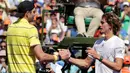 Petenis AS, John Isner berjabat tangan dengan petenis Jerman, Alexander Zverev seusai final Miami Terbuka 2018 di Key Biscayne, Minggu (1/4). John Isner meraih gelar juara Miami Terbuka setelah menang dengan skor, 6-7(4), 6-4 dan 6-4.  (AP/Lynne Sladky)