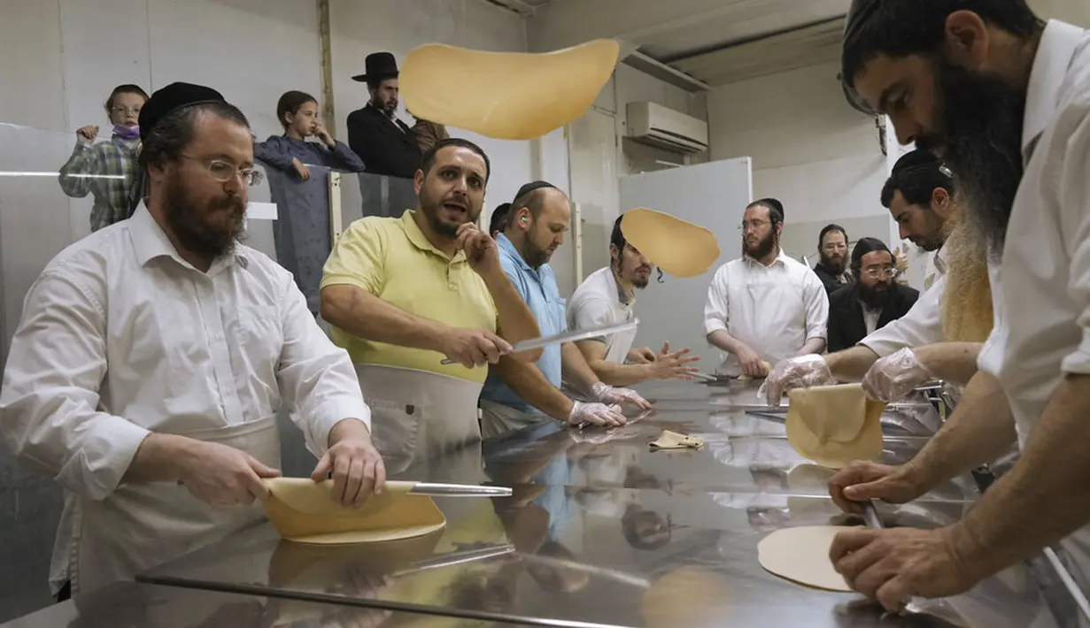 Yahudi Ultra-Ortodoks menyiapkan matzoh khusus di sebuah toko roti di Ashdod, Israel, 11 April 2022. Matzoh adalah roti tradisional tidak beragi yang dibuat untuk Paskah. (AP Photo/Tsafrir Abayov)