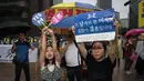 Warga menunjukan poster anti-gay saat acara parade 'Gay Pride' di Seoul, Korea Selatan (15/7). Kelompok anti-gay ini mendesak kaum homoseksual untuk kembali mengikuti ajaran Yesus Kristus. (AFP Photo/Ed Jones)