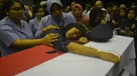 Istri almarhum Lettu Pnb Hanggo F terkulai lemas di depan peti jenasah