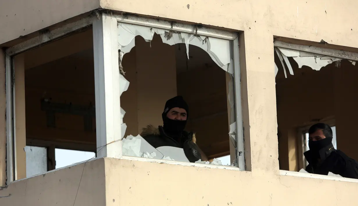 Pasukan keamanan Afghanistan berdiri di sebuah bangunan di Kabul, Afghanistan (15/1). Menurut pejabat setempat, seorang pembom bunuh diri Taliban meledakkan kendaraan bermuatan bahan peledak pada Senin malam. (AP Photo/Rahmat Gul)