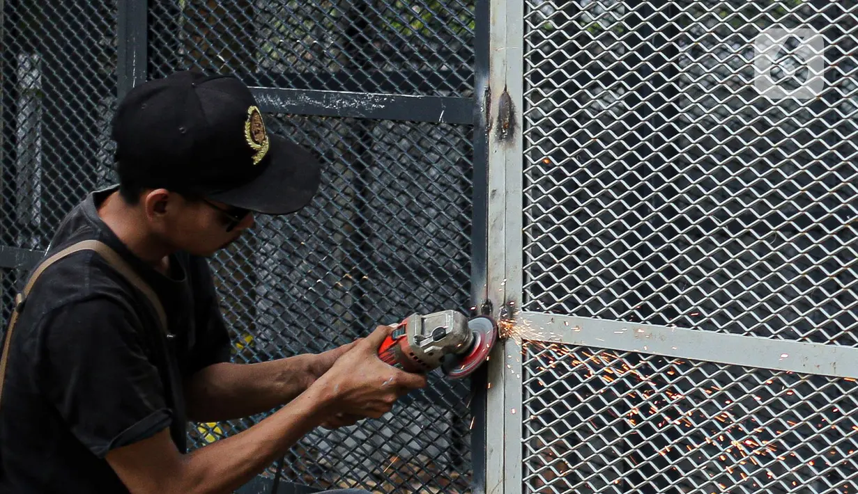 Pekerja melakukan pengelasan saat menyelesaikan pemasangan pagar yang mengelilingi area ruang terbuka hijau (RTH) Tebet Eco Park, Jakarta, Senin (12/12/2022). Pemasangan pagar tersebut membuat taman terkesan lebih rapih dan bagus. (Liputan6.com/Faizal Fanani)