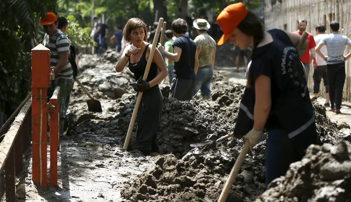 Sejumlah relawan ikut membersihkan di sekitar kebun binatang Tbilisi, Georgia, Senin (15/6/2015). Puluhan satwa mati dan hewan lainnya melarikan diri akibat banjir bandang melanda Kebun Binatang Tbilisi pada Minggu (14/6). (REUTERS/David Mdzinarishvili)