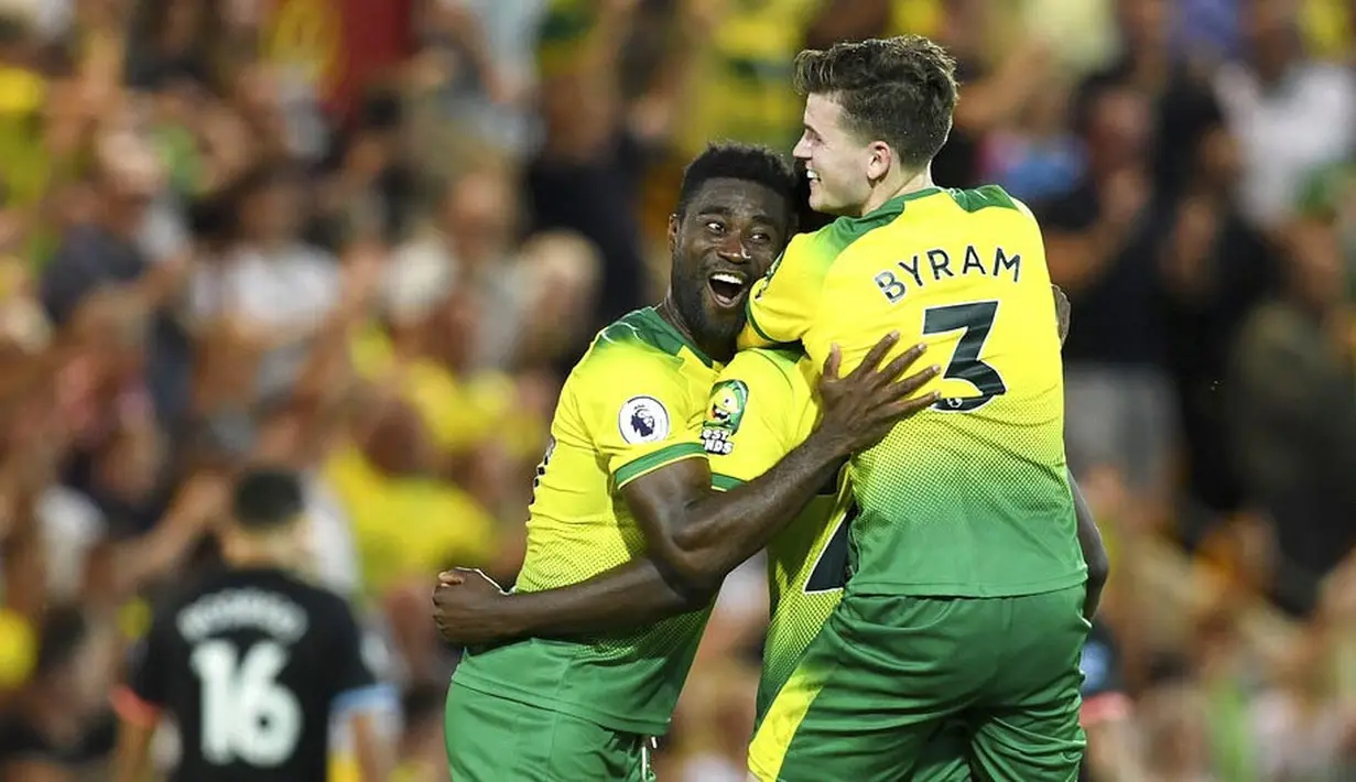 Pemain Norwich City, Alexander Tettey dan Sam Byram merayakan kemenangan atas Manchester City pada laga Premier League di Stadion Carrow Road, Sabtu (14/9). Norwich City menang 3-2 atas Manchester City. (AP/Joe Giddens)