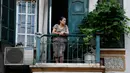 Gambar pada 2 September 2021 menunjukkan seorang perempuan melihat keluar dari balkon rumahnya di Hanoi, Vietnam, selama lockdown Covid-19. Menghadap ke jalan yang sepi, balkon kecil mereka menjadi saksi bisu terkait aktivitas yang dilakukan oleh masing-masing keluarga. (Nhac NGUYEN/AFP)