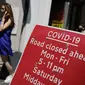 Pejalan kaki berjalan melewati tanda yang menunjukkan jalan ditutup di daerah Soho, pusat kota London, Kamis (3/6/2021). Pemerintah Inggris belum bisa memastikan akan sepenuhnya mencabut lockdown yang berakhir pada 21 Juni nanti meski kasus Covid-19 mengalami tren penurunan. (Tolga Akmen/AFP)