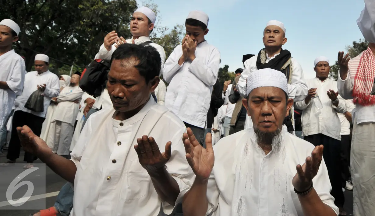 Demonstran berdoa setelah melakukan salat ashar berjamaah di depan Balai Kota, Jalan Medan Merdeka Selatan, Jakarta, Jumat (4/11). Di sela-sela salat Ashar, sebagian massa aksi juga ada yang memanfaatkan untuk istirahat. (Liputan6.com/Yoppy Renato)