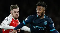 Gelandang Manchester City, Raheem Sterling (kanan) berusaha membawa bola dari kejaran gelandang Arsenal, Aaron Ramsey pada lanjutan liga Inggris di Stadion Emirates (21/12). Arsenal menang atas City dengan skor 2-1. (AFP PHOTO/ADRIAN DENNIS)